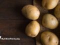 Fresh white potatoes on an old wooden table