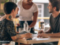 Two people out to eat with a server at the table