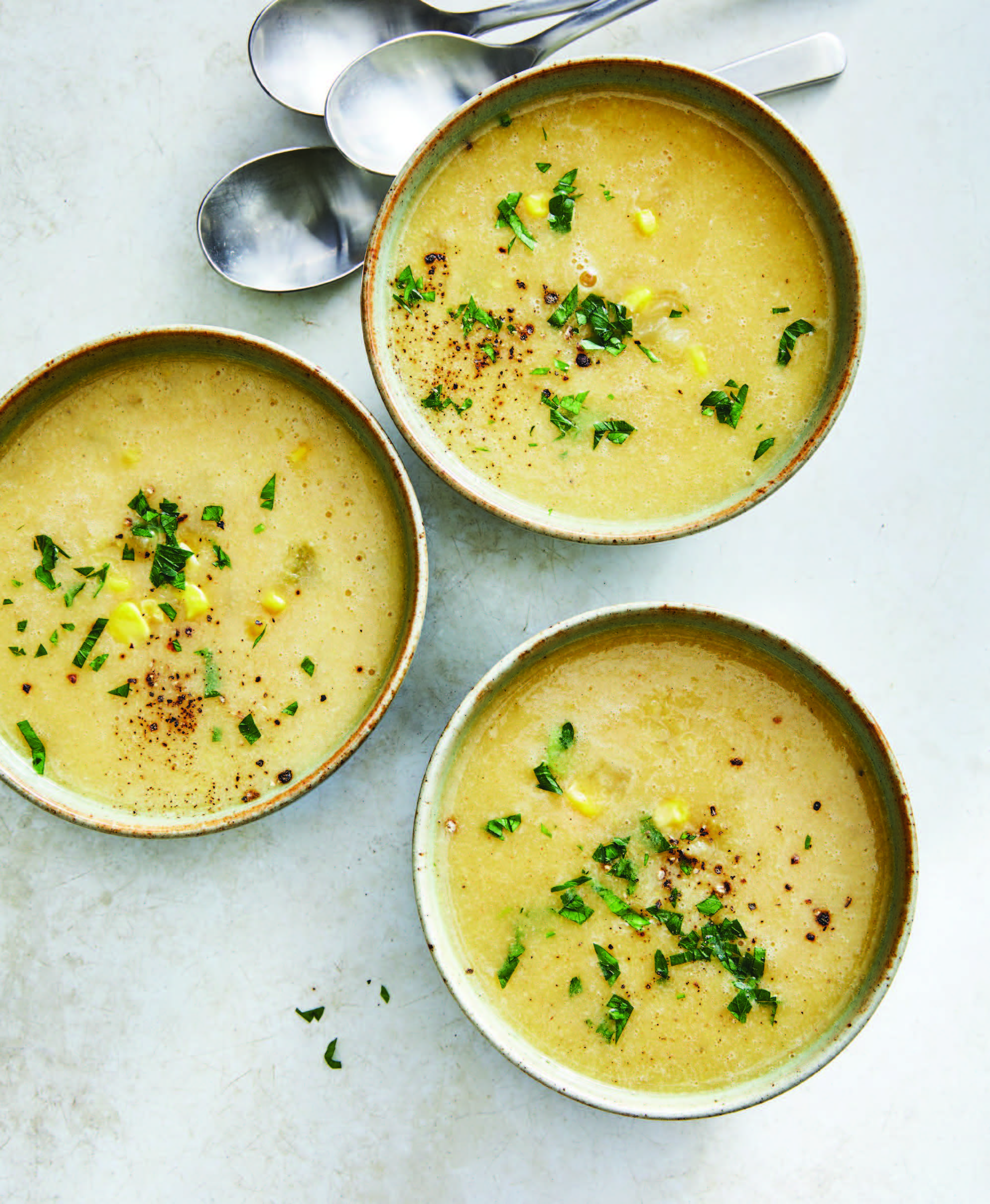 three ceramic bowls filled with corn chowder