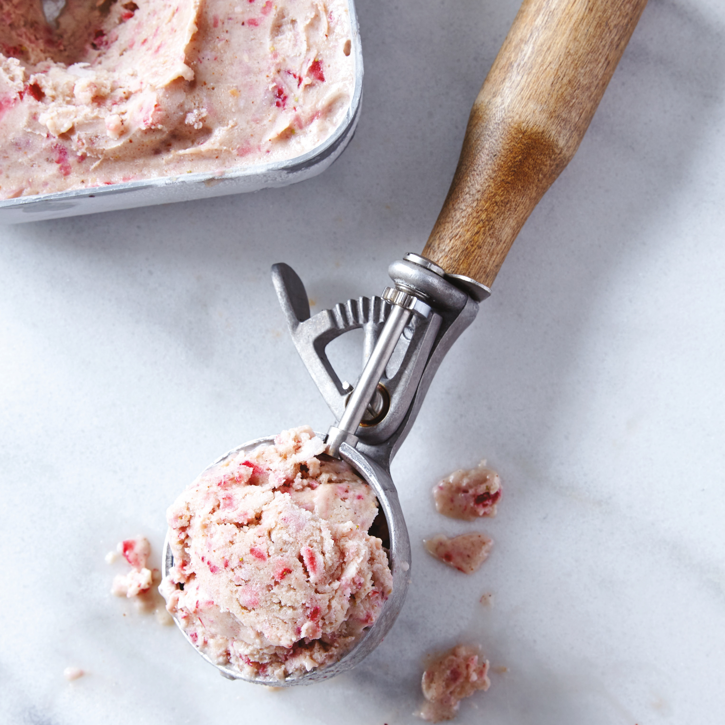 container and ice cream scoop of berry nice cream
