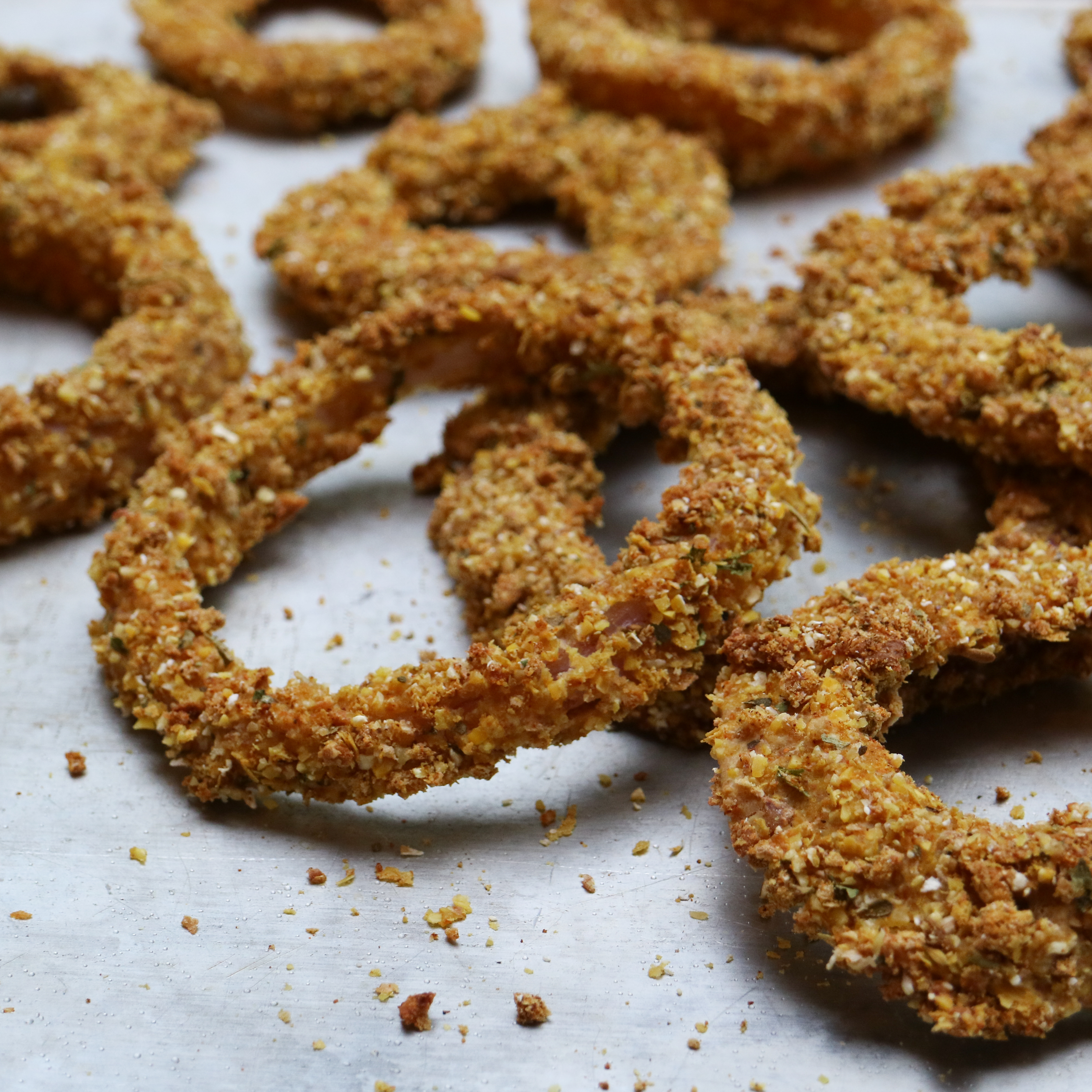 baked onion rings laid out on a tray