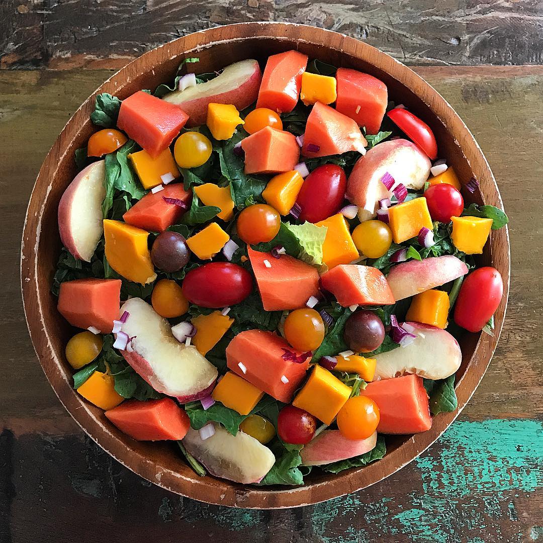 large wooden bowl filled with various fruits and vegetables