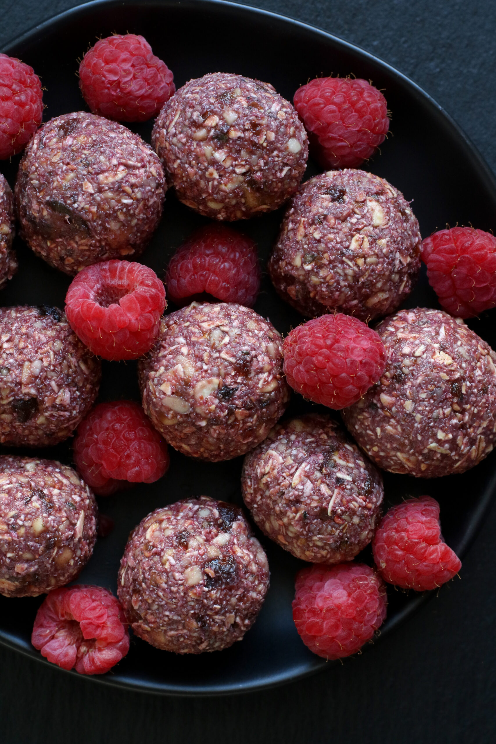 raspberry power balls and fresh raspberries in a dish
