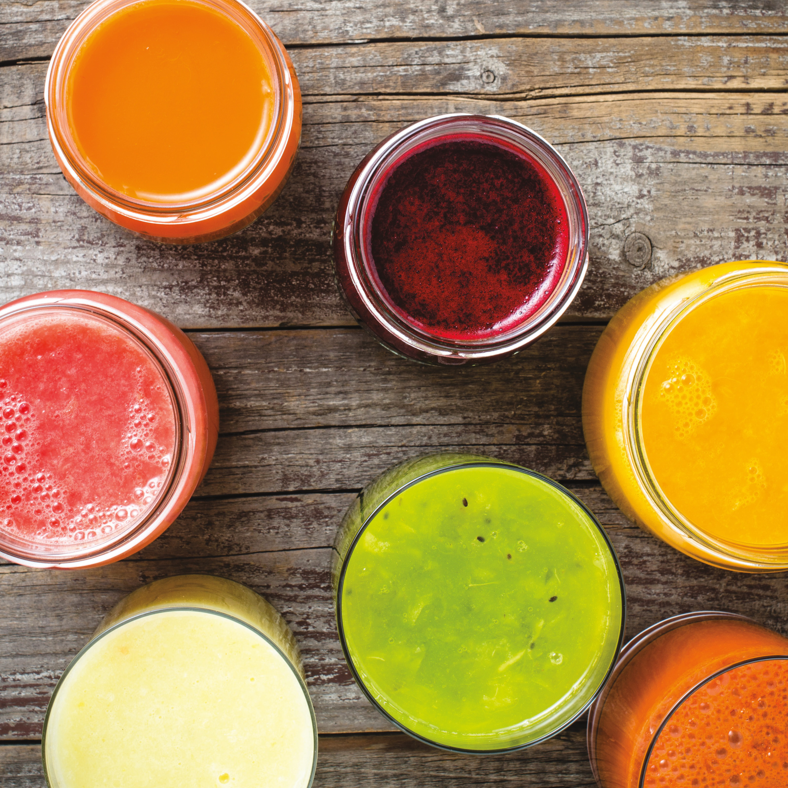 seven glasses of various fruit and vegetable juices