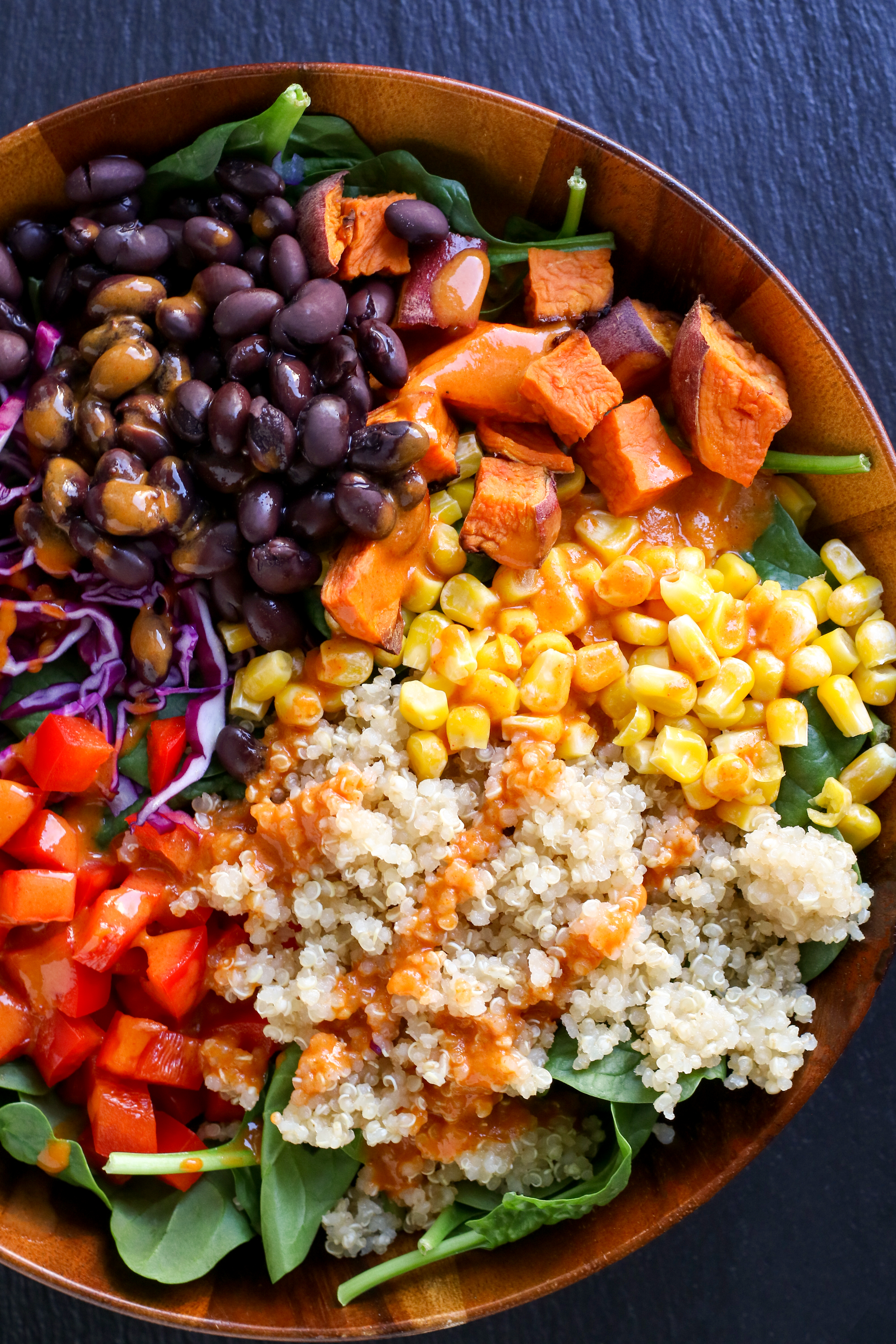 large bowl of grains, beans, and vegetables, topped with sweet and smokey sauce